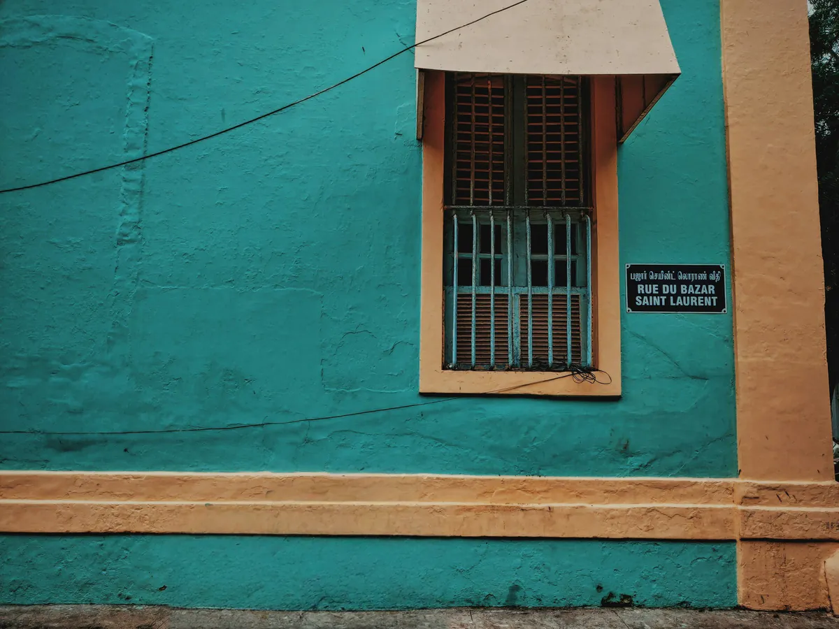 Parked bicycle removed from in front of a teal colonial facade