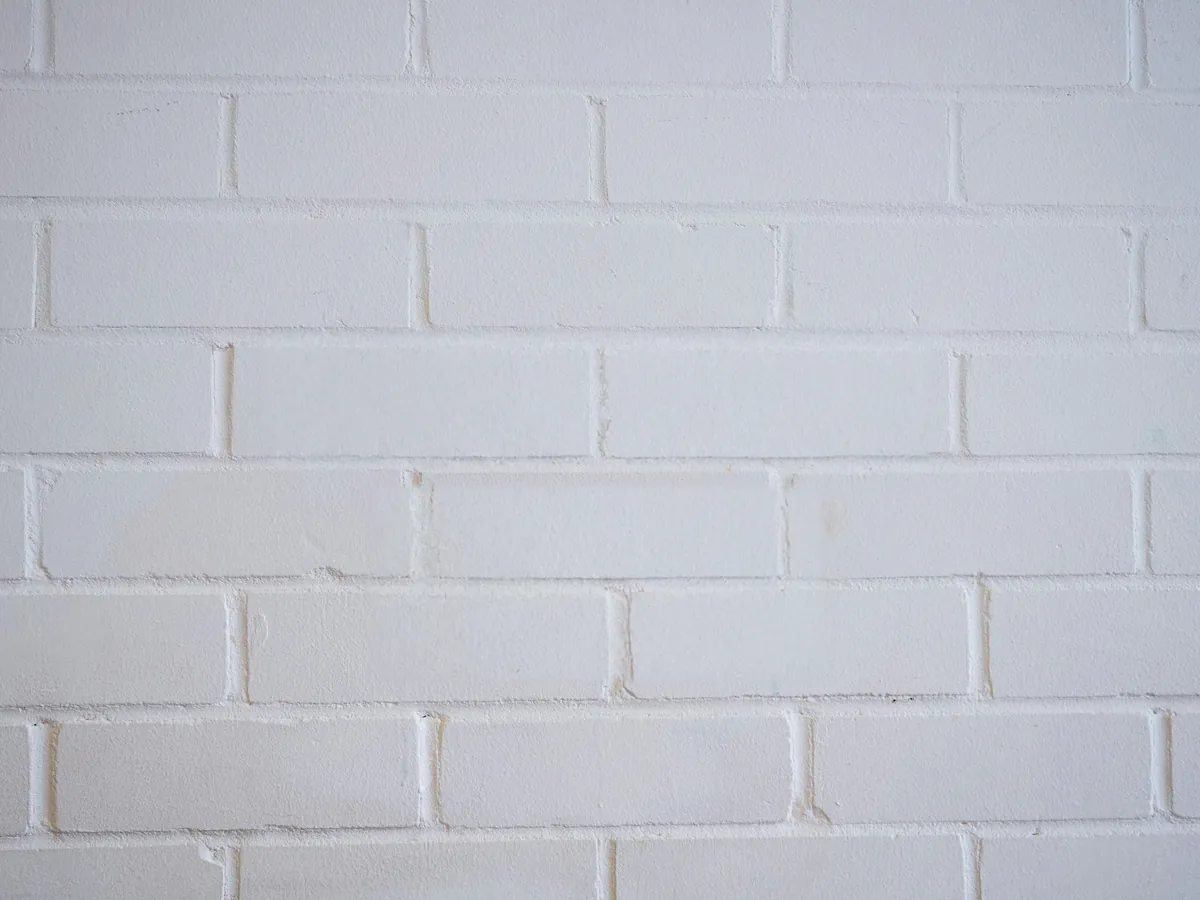 Stencilled ONE WAY sign removed from a white brick wall